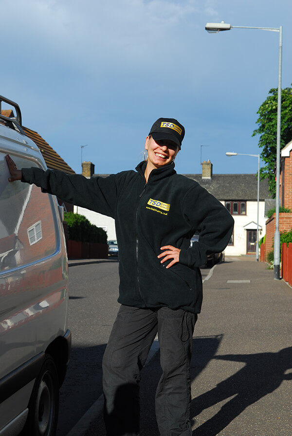 TSD cleaner in uniform and cap outside a London home